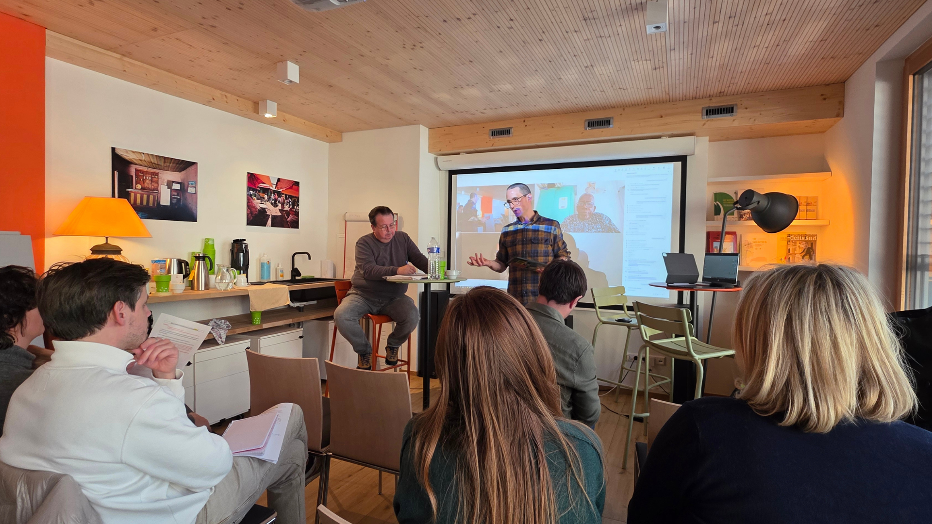 Intervention lors de l’atelier UNDROP : un participant s’exprime devant l’équipe de SOS Faim réunie en salle, avec une visioconférence projetée à l’écran.