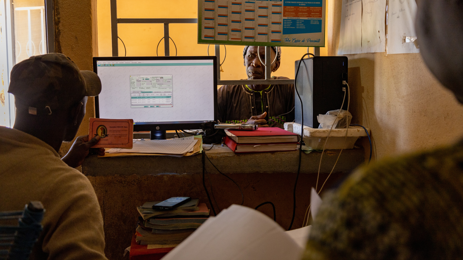 Producteur en train de discuter avec un agent d’une institution financière pour une demande de crédit agricole.